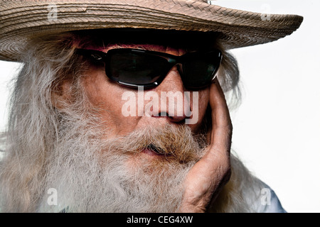 A senior Caucasian man with a long gray beard, mustache and wearing sunglasses and a straw hat, Stock Photo