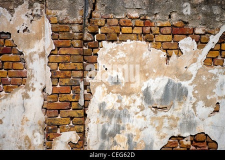 old weathered brick wall with peeling plaster Stock Photo