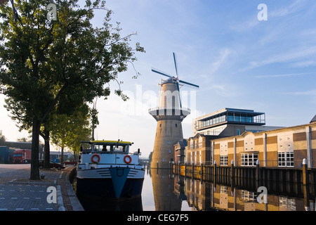 Mill and ship with reflection in water at sunrise - horizontal image Stock Photo