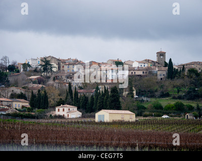 the hilltop village of Bellegarde-du-Razes in Aude, Languedoc, France, with vineyards at the foot of the hill in the foreground Stock Photo