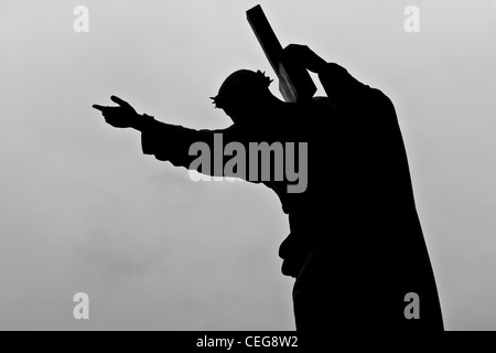Silhouette of Jesus carrying his cross Stock Photo