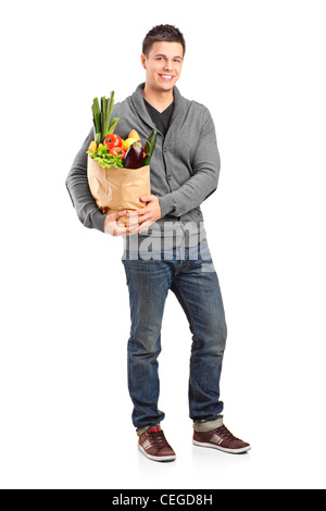 Full length portrait of a smiling male holding a paper bag full of groceries isolated on white background Stock Photo