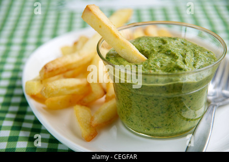 French fries with a tasty vegan cheddar style (dairy free) spinach dip. Stock Photo