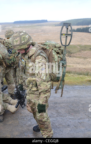 A British army solder 'Vallon man' looking for IED's using a Vallon metal detector, he will lead a patrol, sweeping the route fo Stock Photo