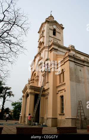 House painter perched on top of a ladder in a church, Parroquia (Parish) Virgen del Rosario, Luque, Paraguay Stock Photo