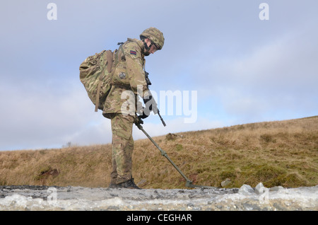 A British army solder 'Vallon man' looking for IED's using a Vallon metal detector, he will lead a patrol, sweeping the route fo Stock Photo