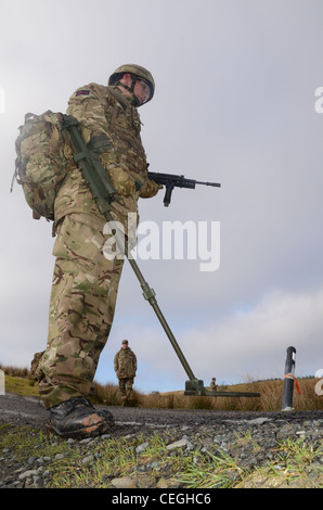 A British army solder 'Vallon man' looking for IED's using a Vallon metal detector, he will lead a patrol, sweeping the route fo Stock Photo