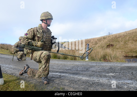 A British army solder 'Vallon man' looking for IED's using a Vallon metal detector, he will lead a patrol, sweeping the route fo Stock Photo