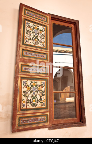 A reflection in a window of the inner courtyard of Ben Youssef Madrasa, Marrakesh, Morocco Stock Photo