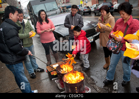 Chinese-Americans burning symbolic money for luck on the streets of New York City's Chinatown during 2012 Lunar New Year Stock Photo