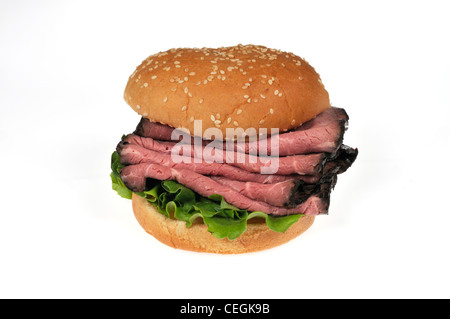 Roast beef sandwich on sesame seed  bread roll on white background cutout. Stock Photo