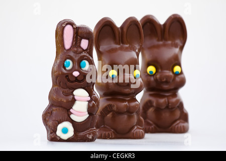 Happy Easter chocolate Bunnies unwrapped three sweets isolated cutout cut out on white background picture images horizontal in USA US hi-res Stock Photo