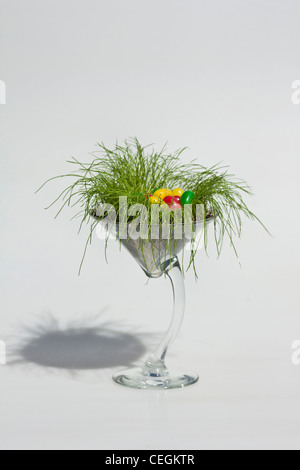 Happy Easter colorful jellybeans candies decorations in the glass cup on white background cut out cutout isolated vertical format in USA US hi-res Stock Photo