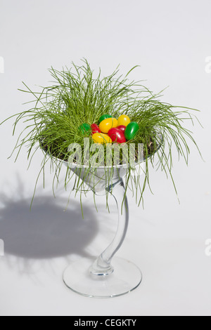 Happy Easter colorful jellybeans candies decorations in the glass cup on white background cut out cutout isolated vertical fomat in USA US  hi-res Stock Photo