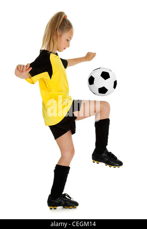 Full length side view of eight year old girl with soccer ball, isolated on white background. Stock Photo