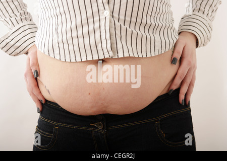 Woman with large stomach standing with hands on hips. Stock Photo