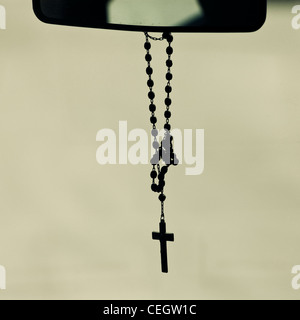 Crucifix hanging from mirror in a car Stock Photo