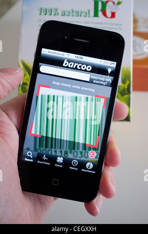 Scanning barcode on packet of tea to find price comparison in shop on an iPhone 4G smart phone Stock Photo