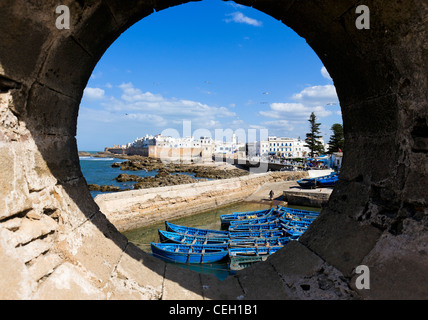 View of the old town from the walls of the Skala du Port with local fishing boats in the foreground, Essaouira, Morocco Stock Photo
