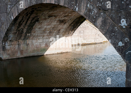 Water flowing under the bridge at Cadover, Dartmoor, Devon UK Stock Photo