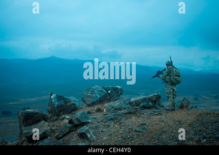 KHOWST PROVINCE, Afghanistan — U.S. Army Sgt. Casey Felton, a native of Lewiston, Idaho, and member of 3rd Platoon, Battery A, 2nd Battalion, 377th Parachute Field Artillery Regiment, Task Force Spartan, scopes out a spot to conduct a call for fire exercise with the M-777 155mm howitzer crews on Forward Operating Base Salerno at dusk on Feb. 3. 3rd Plt. climbed to the top of a mountain several miles away from the FOB to put eyes on the taget area in the valley below. Stock Photo