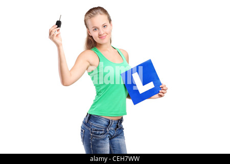 A teenager holding a L plate and car key isolated on white background Stock Photo