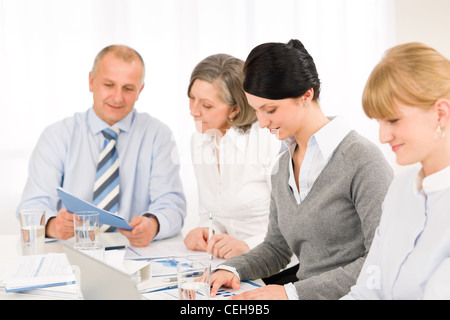 Businesswoman at team meeting with colleagues discussing performance reports Stock Photo