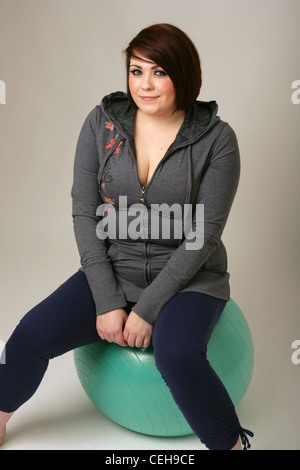Overweight woman sitting on an exercise ball. Stock Photo