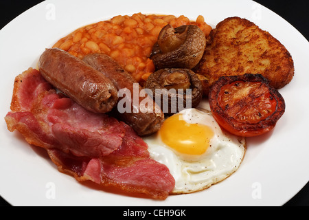 Typical fry up consisting of Sausage, bacon, egg, mushrooms, hash browns, beans and Fried Tomato Stock Photo