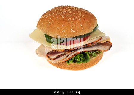 Sliced turkey with cheese, lettuce, tomato and green pepper sandwich on sesame seed roll on white background cutout. Stock Photo