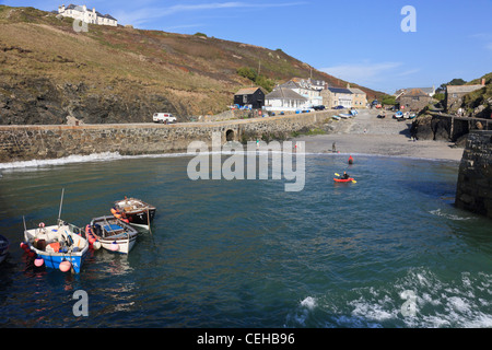 Small boats moored in old fishing village harbour on the Cornish coast. Mullion Cove, Cornwall, England, UK, Britain. Stock Photo