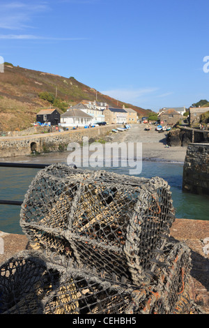 Lobster pots on the harbour wall in picturesque fishing village on the Cornish coast. Mullion Cove Cornwall England UK Britain Stock Photo