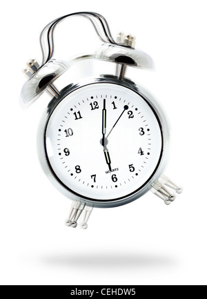 Classic white alarm clock ringing at six o'clock, isolated against a white background Stock Photo