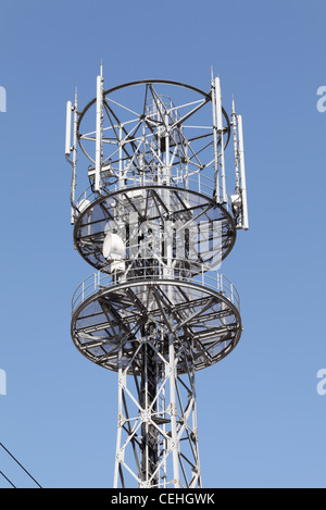 Cell phone tower rises against a blue sky Stock Photo