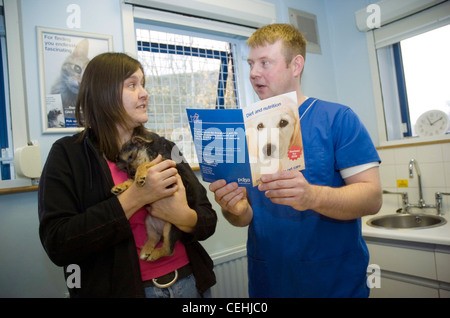 Woman chatting with vet about nutrition at PDSA clinic. Stock Photo
