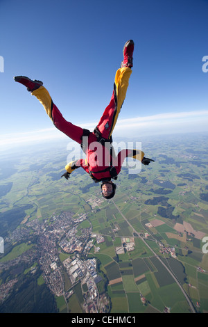 Skydiver girl is practice the head down position and flying free over nice landscape with over 150 MPH. Stock Photo