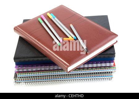 Felt-tip pen on a pile of writing-books and organizers white background Stock Photo