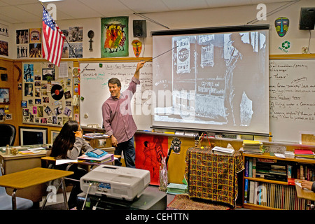 A history teacher uses a liquid crystal display (LCD) projector while lecturing to his class on the Great Depression. Stock Photo