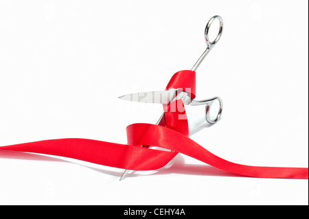 Scissors cutting through a red ribbon Stock Photo