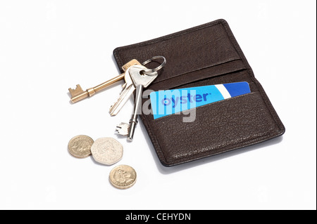 An Oyster card in a leather holder with keys and British coins Stock Photo