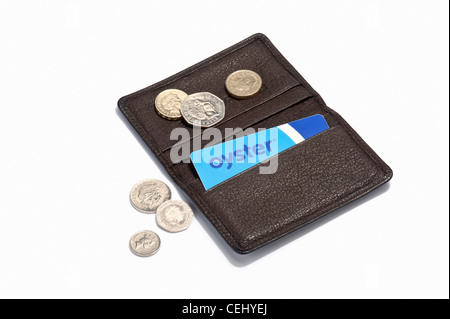 An Oyster card in a leather holder and British coins Stock Photo