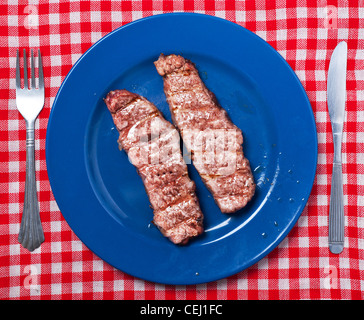 Grilled meat on blue plate. Stock Photo