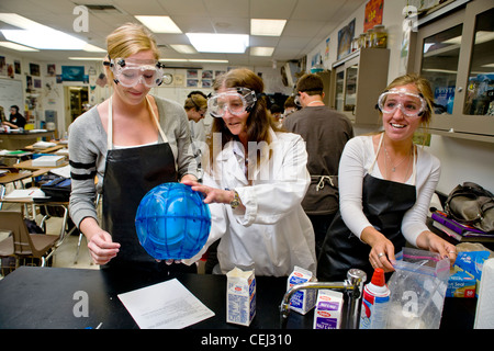 A high school teacher in San Clemente CA, assists her students with a solution chemistry experiment in freezing point depression Stock Photo