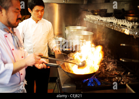 A chef stir frying with a wok, at a Korean restaurant. Stock Photo