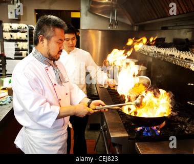 A chef stir frying with a wok, at a Korean restaurant. Stock Photo