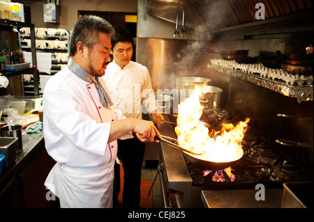 A chef stir frying with a wok, at a Korean restaurant. Stock Photo