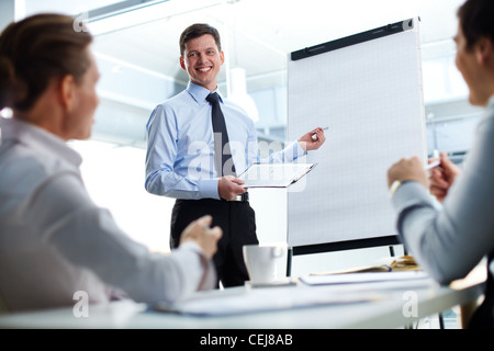 Cheerful businessman discussing a new business project with the members of his team Stock Photo