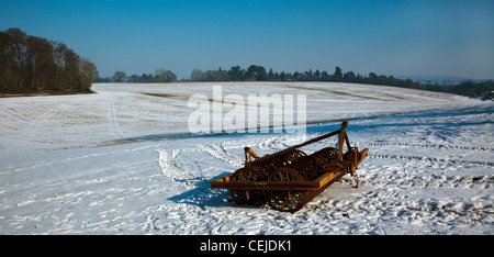 Tractor implement in a snowy Chiltern Hills field Oxfordshire England UK Stock Photo