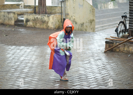 Kid wearing raincoat and returning from School - Scenes from Mumbai Stock Photo