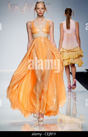 Byblos Milan Ready to Wear Spring Summer Russian model Polina Kouklina wearing shiny chiffon flowing orange gown Stock Photo